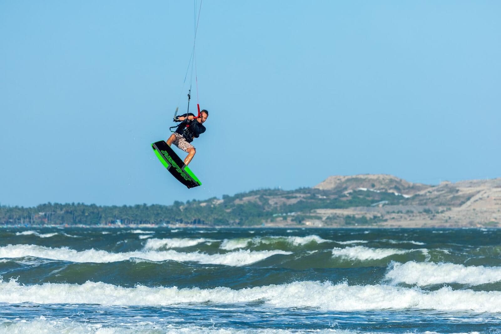 Kitesurfer in de lucht boven de golven