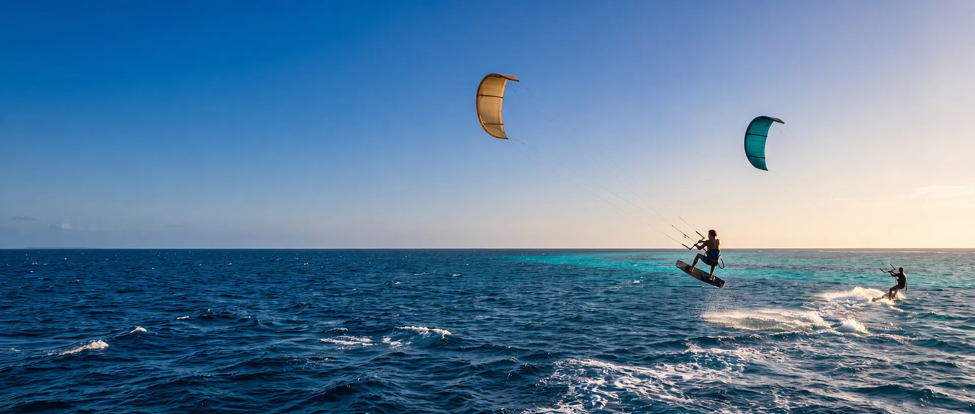 Kitesurfers op turquoise water in de middagzon