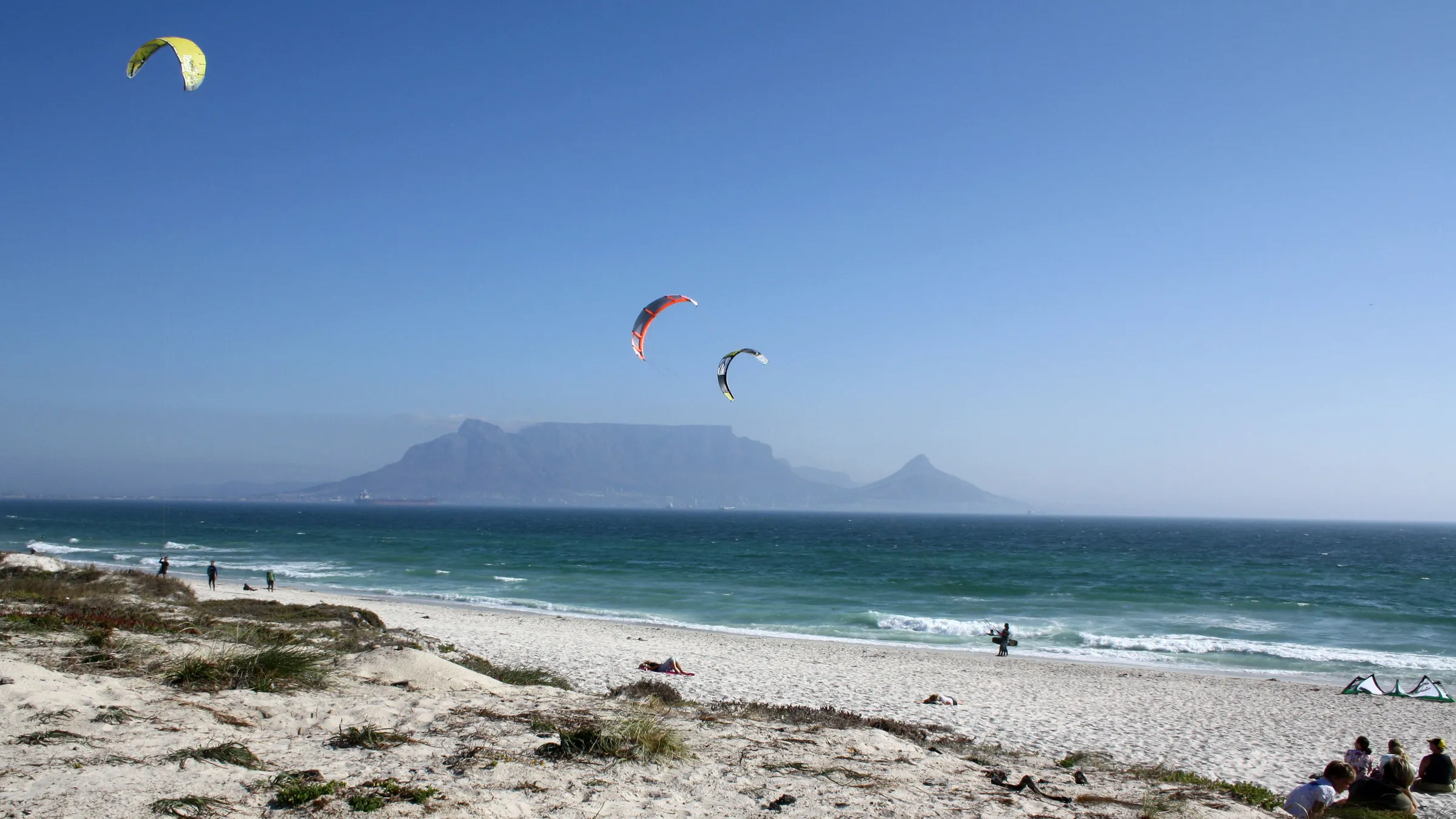 Kites boven het strand van Bloubergstrand met de Tafelberg aan de overkant van de baai