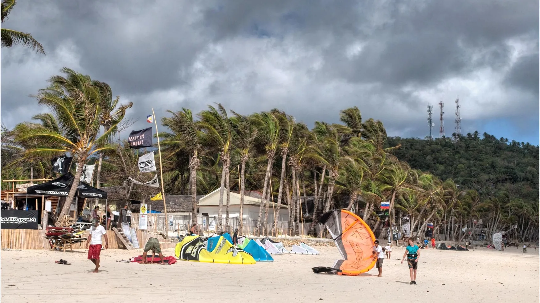 Kites op het witte zand van Bulabog Beach tussen de palmbomen