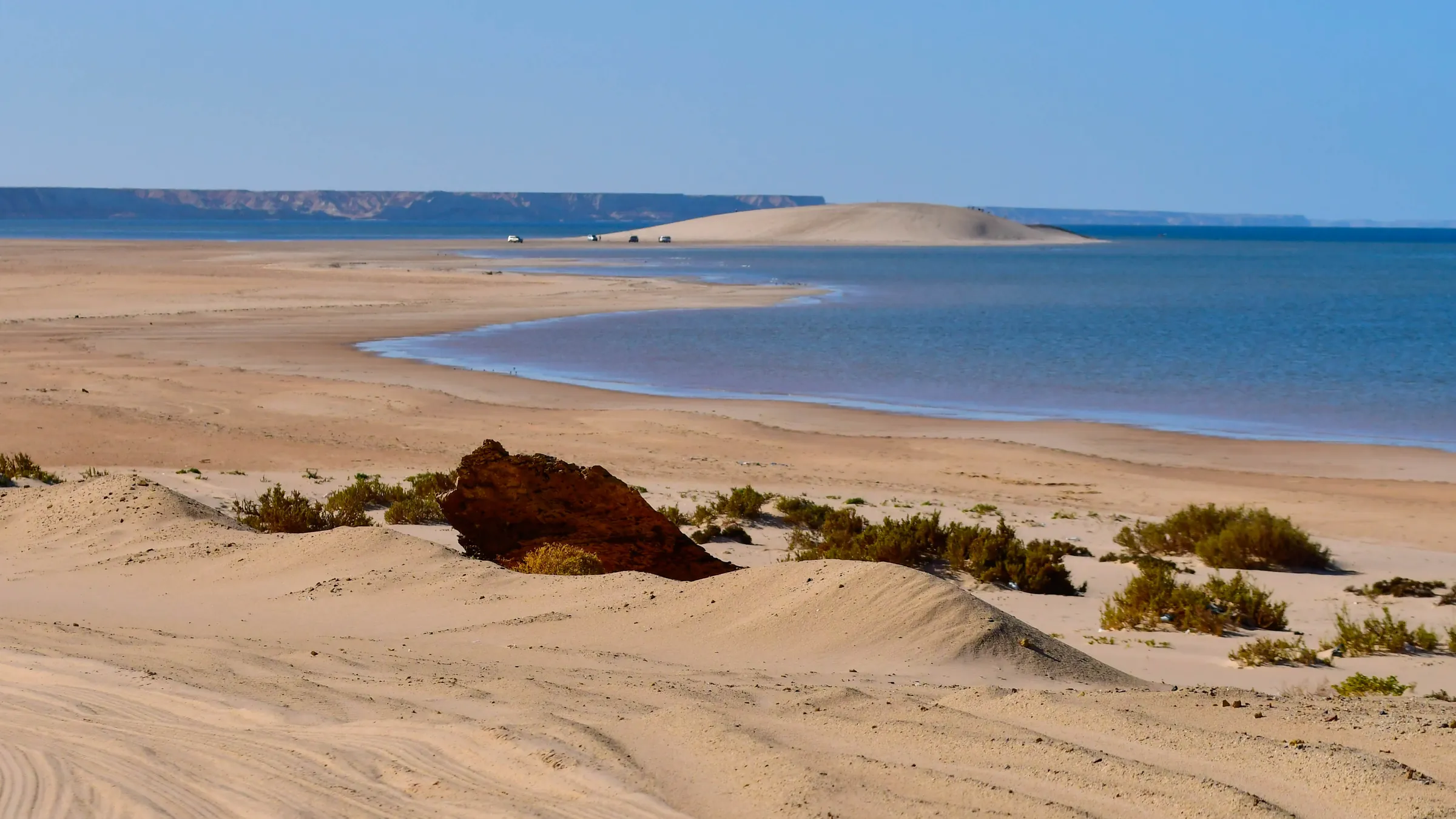 Duinlandschap met uitzicht over de kronkelende lagune van Dakhla