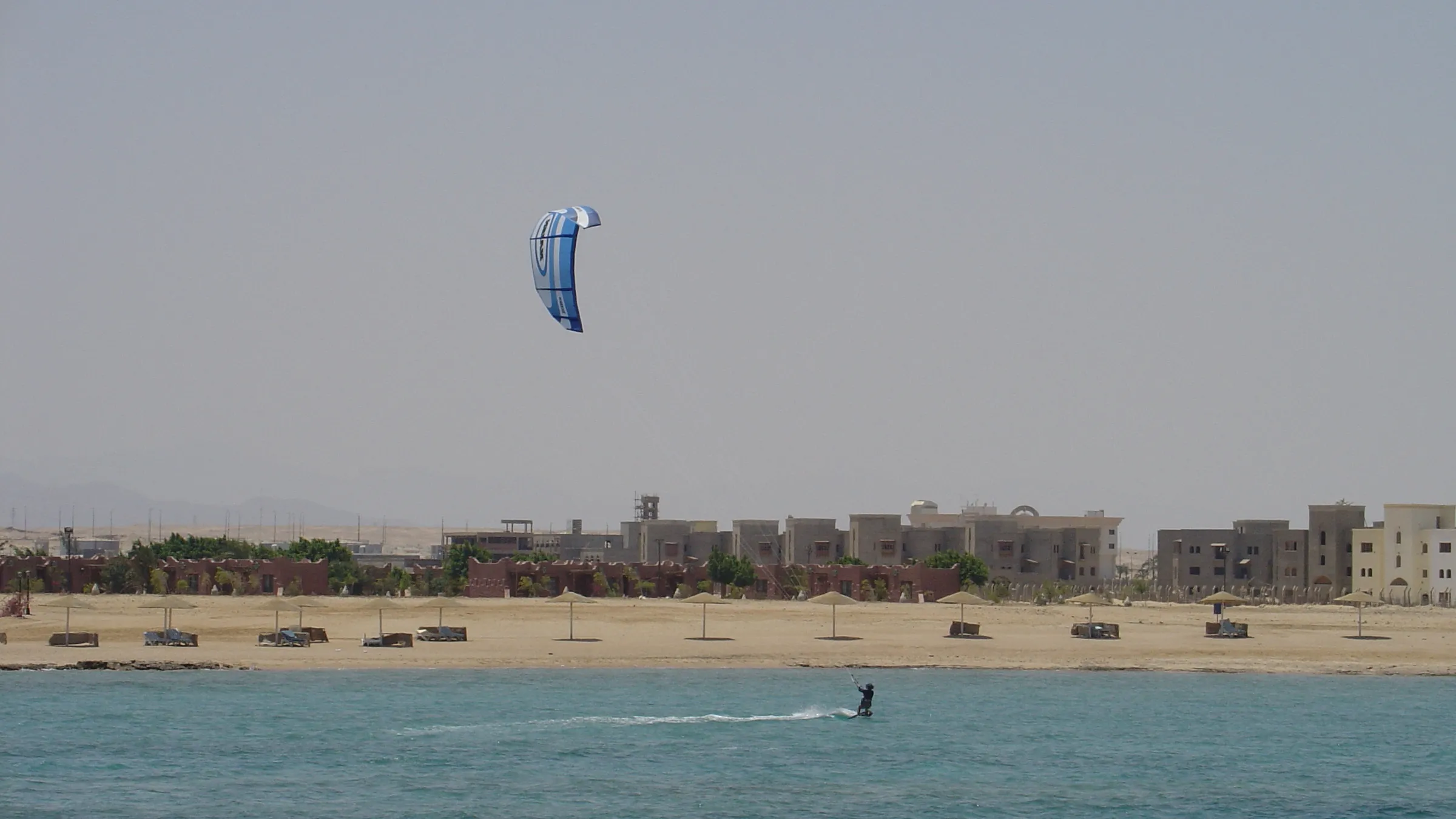 Kitesurfer op de Rode Zee voor een hotelstrand bij Hurghada