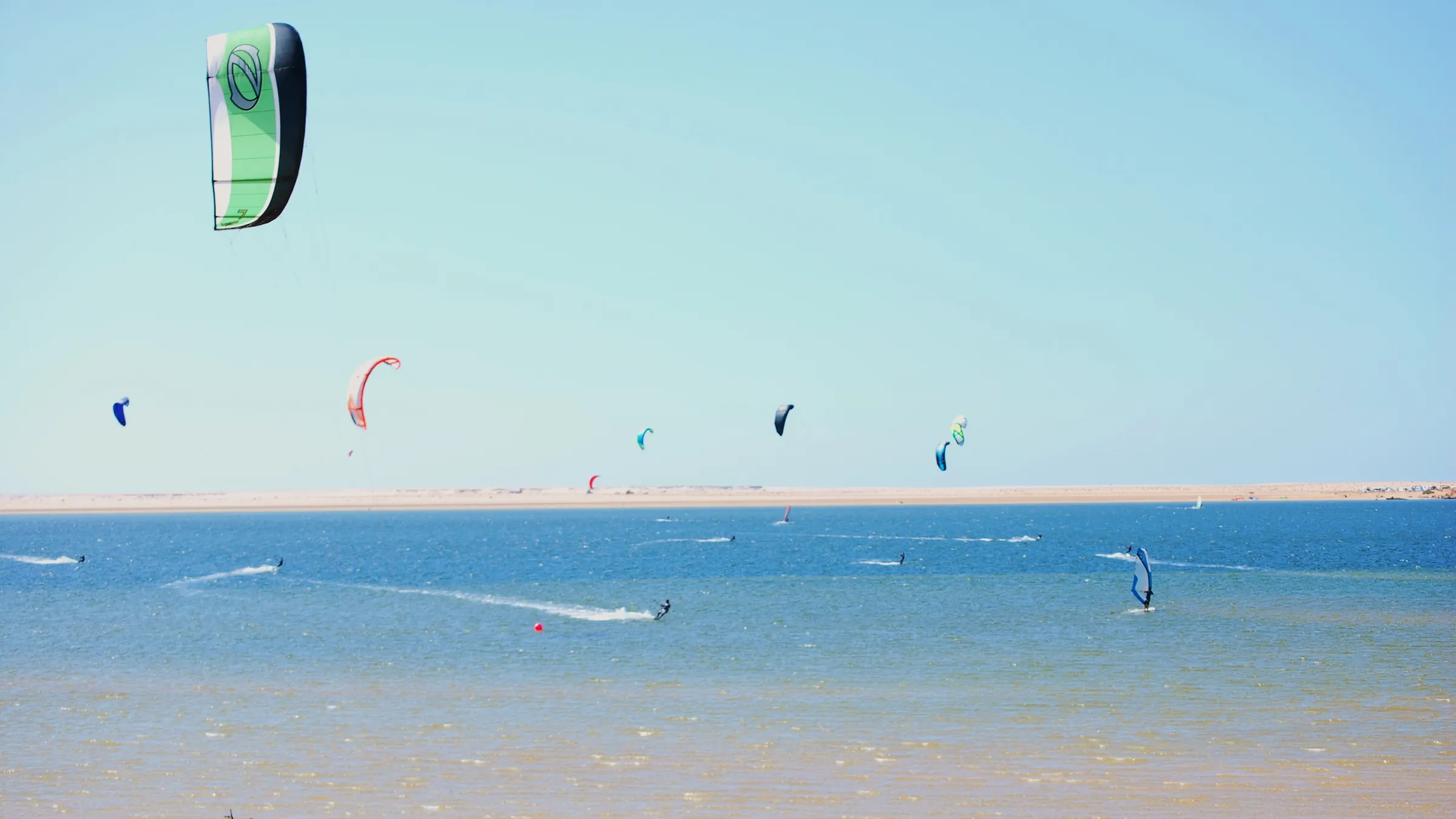Kleurige kites boven de ondiepe lagune van Dakhla