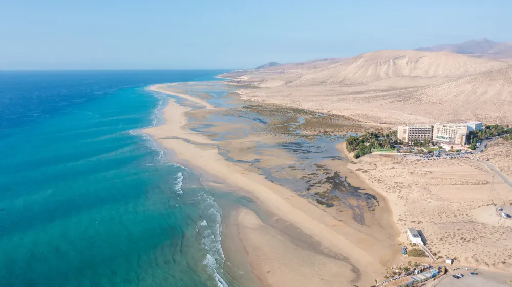 Luchtfoto van de lagune van Sotavento bij laag water, met de zandbank, de oceaan en de bergen van Jandía