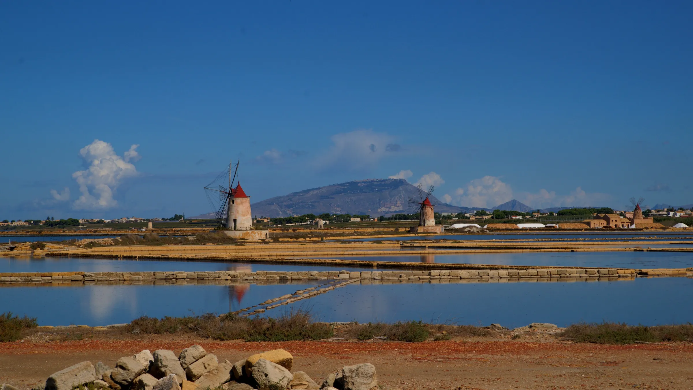 Zoutpannen met windmolens aan de lagune van Lo Stagnone, met de berg van Erice op de achtergrond