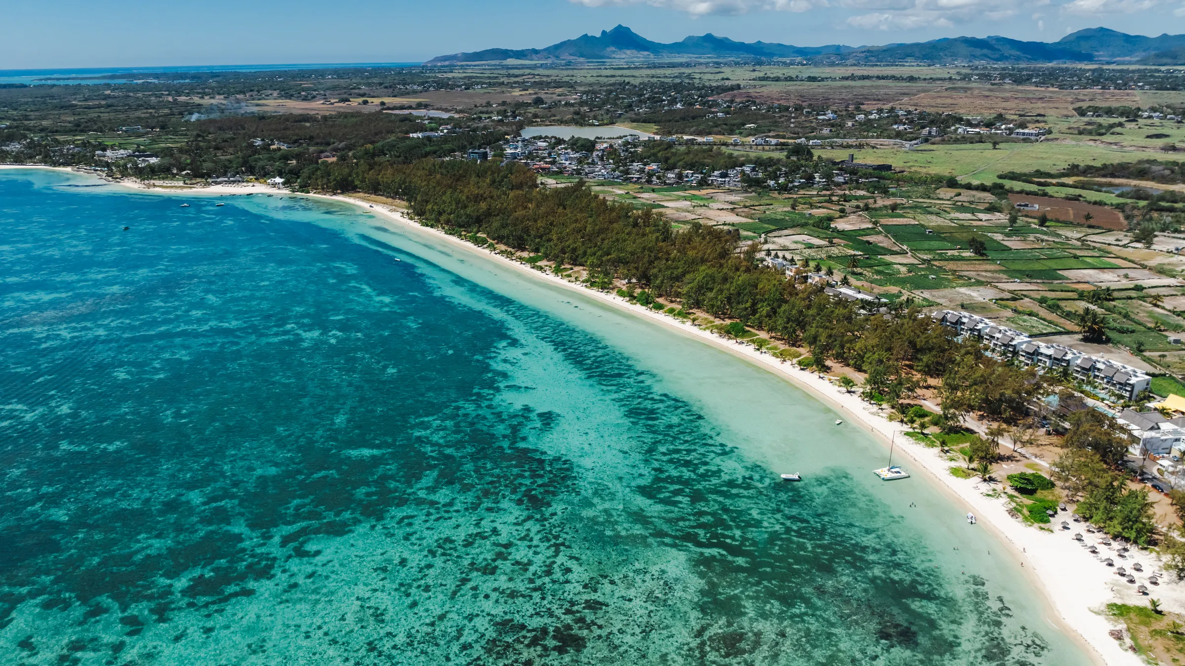 Luchtfoto van het lange strand van Belle Mare met de ondiepe lagune en het koraal