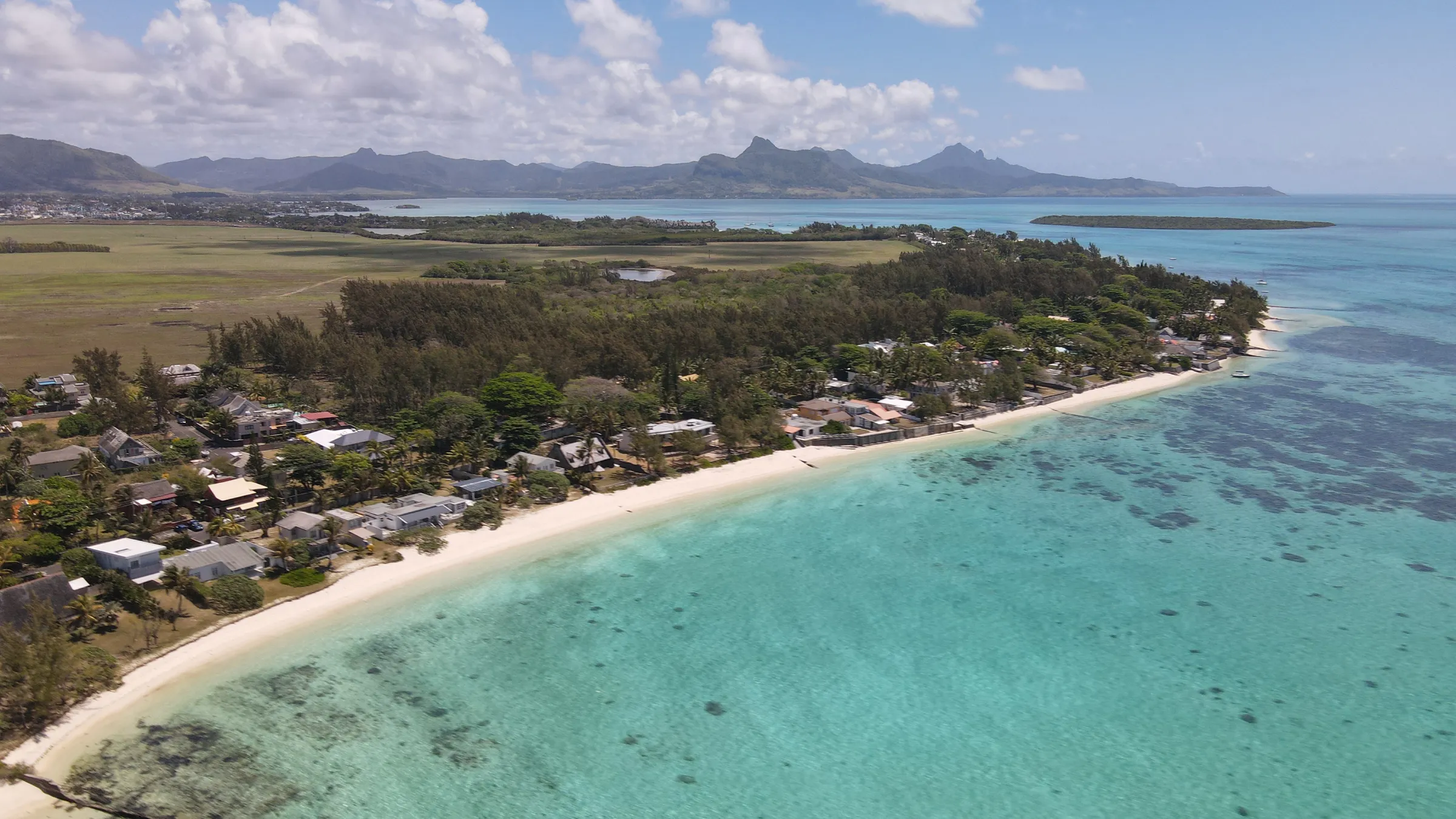 Luchtfoto van de turquoise lagune bij Pointe d'Esny met de bergen op de achtergrond