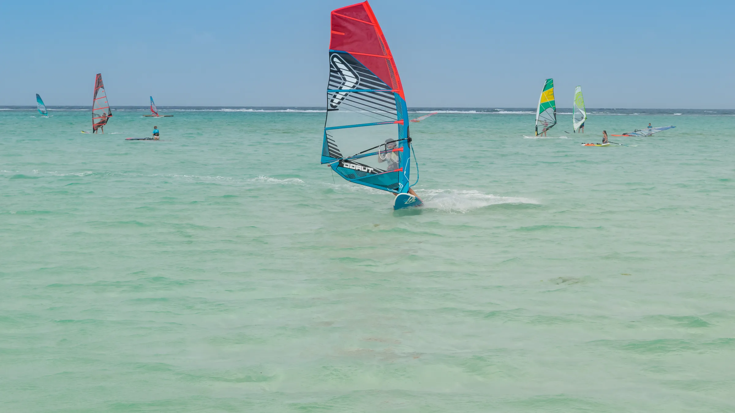 Windsurfers op het ondiepe, turquoise water van Lac Bay bij Sorobon