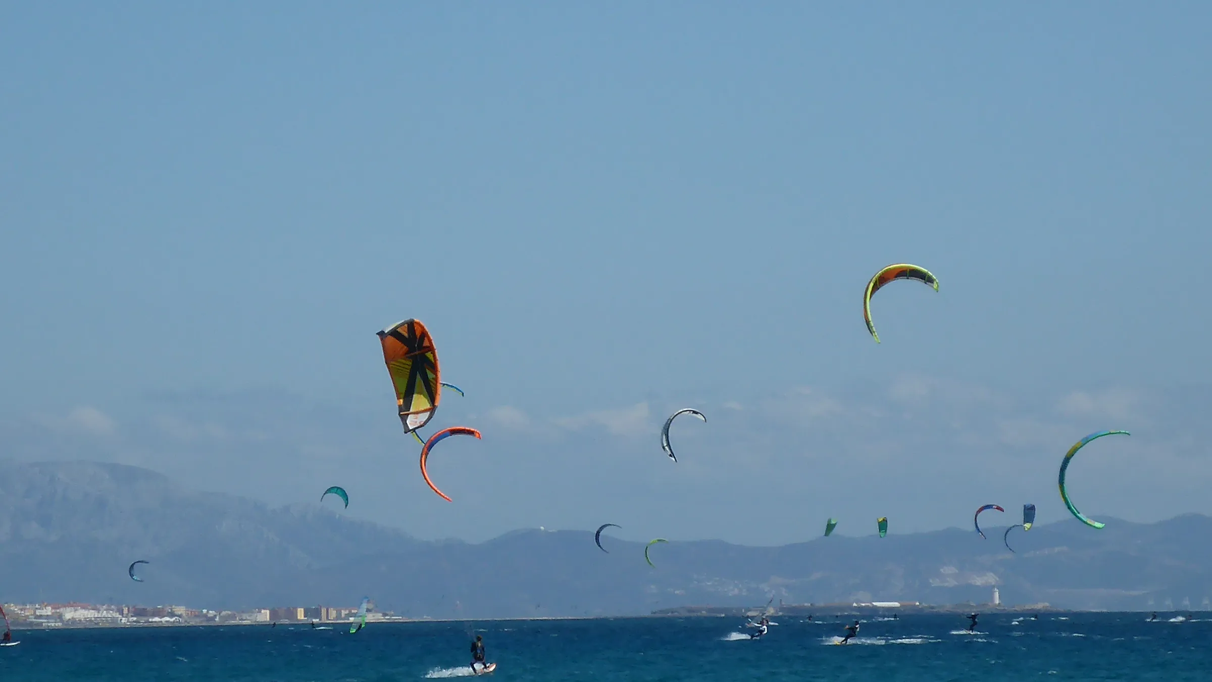 Kites boven het water bij Valdevaqueros, met Tarifa en de bergen van Marokko op de achtergrond