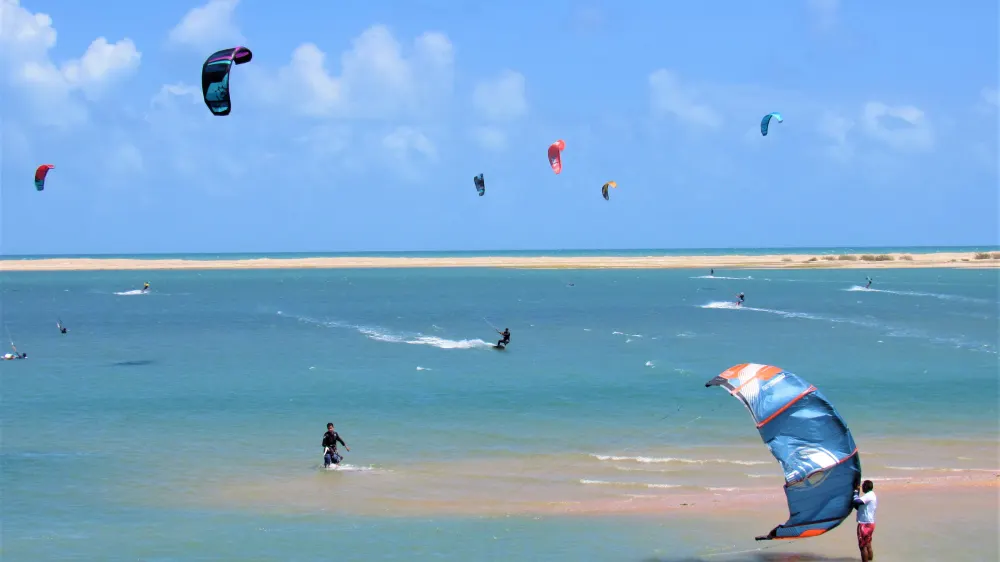 Kitesurfers op de ondiepe lagune van Ilha do Guajiru, met een zandbank aan de horizon